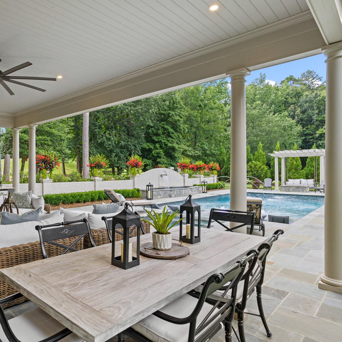 Luxury outdoor patio design with elegant dining area and ceiling fan by BKF Builders.